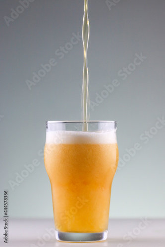 Pouring beer in the glass with nice foam formation
