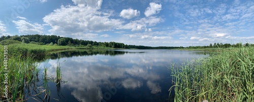 Panoramic view of the lake, blue sky with clouds.
