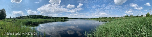 Panoramic view of the lake, blue sky with clouds.