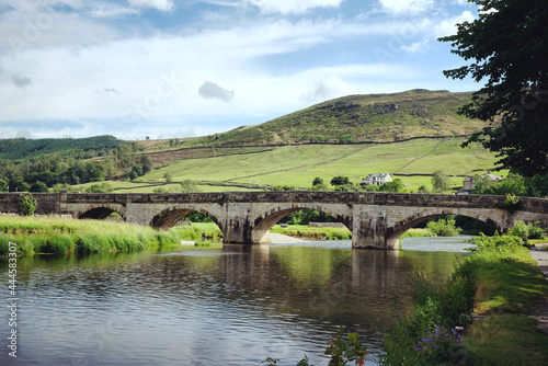Burnsall Bridge over the River Wharfe toward Burnsall and Thorpe Fell, in the Yorkshire Dales, North Yorkshire.