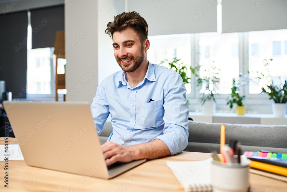 Young man freelancer working on laptop from home office
