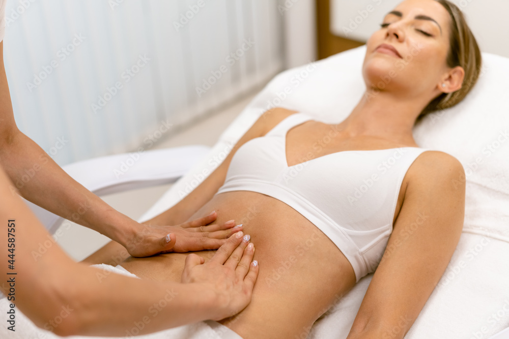 Fototapeta premium Middle-aged woman having a belly massage in a beauty salon.