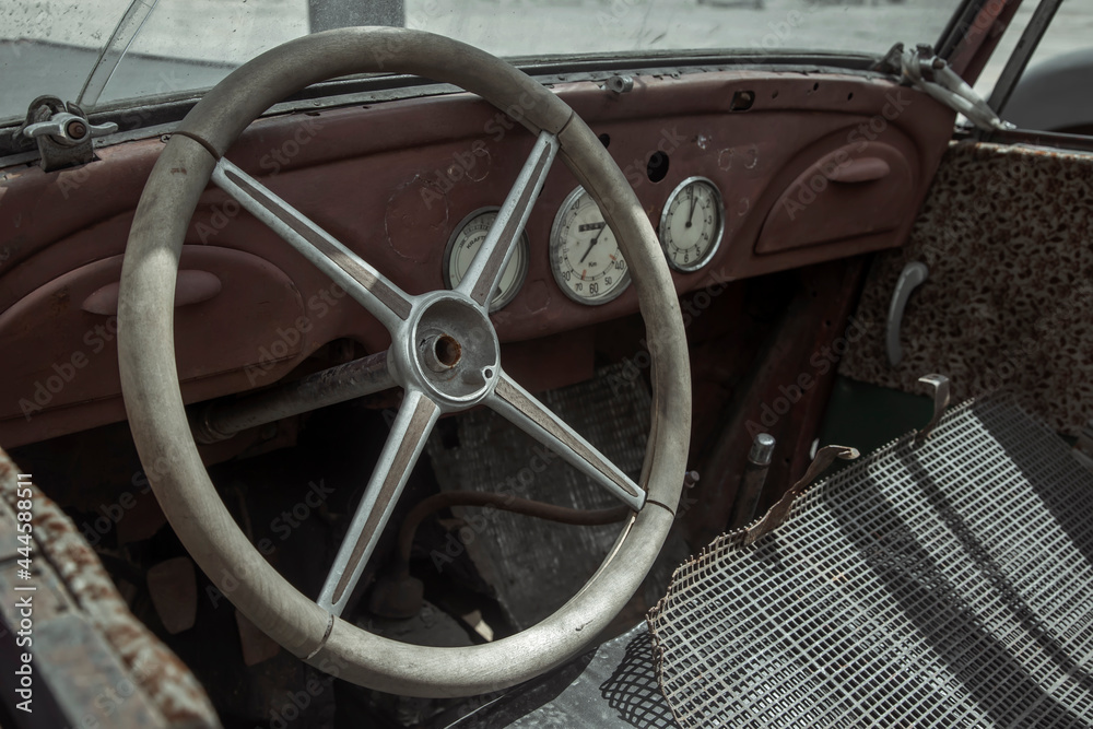 Old cabin of a rusty abandoned truck. Steering wheel and dashboard. Forgotten and abandoned car.