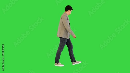 Young asian man in casual clothes walks looking around on a Green Screen, Chroma Key.