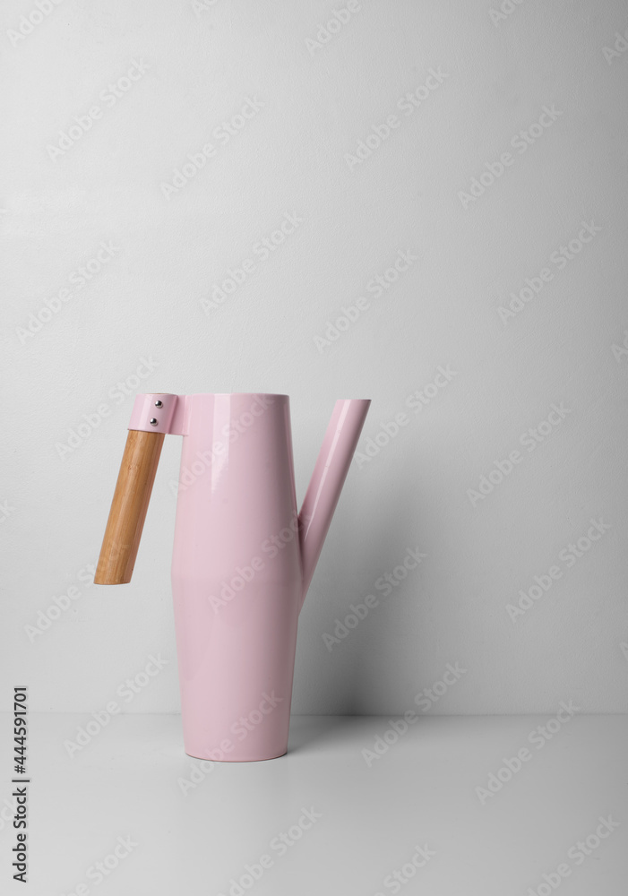 Watering can with a wooden handle on white (light) background Watering can with a wooden handle on white (light) background