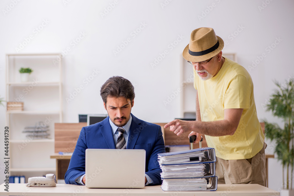 Old boss and young male employee in summer vacation concept Old boss and young male employee in summer vacation concept