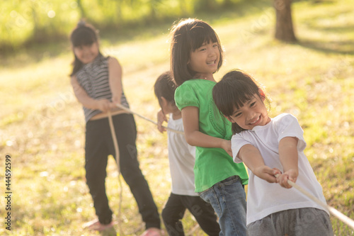 Children playing tug of war at the park on sunsut