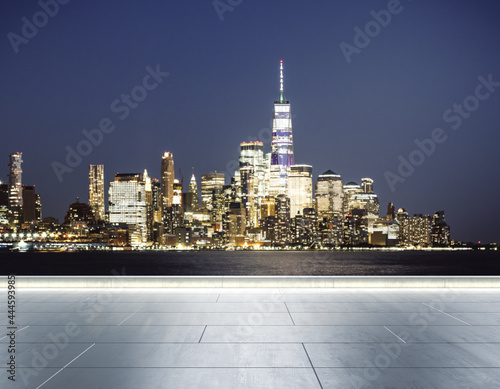 Empty concrete quay on the background of a beautiful blurry Manhattan skyline at twilight, mock up