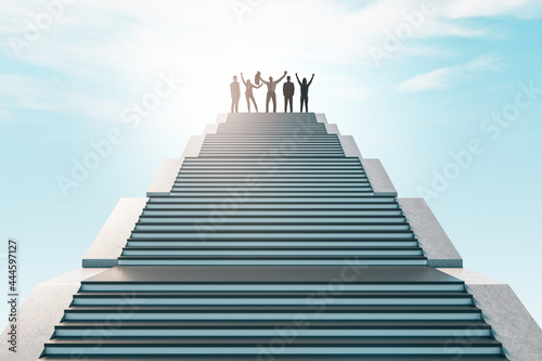 Cheerful businesspeople standing on top of staircase on bright sky background. Success  teamwork and achievement concept.