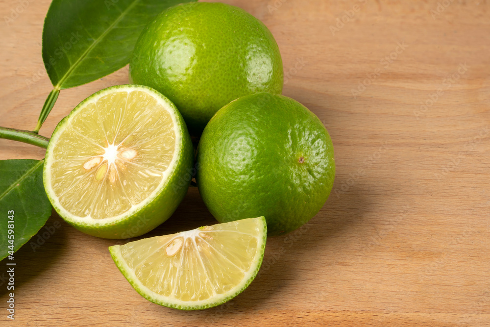 Close up natural fresh lime with sliced, green leaf, on wooden table. Close up natural fresh lime with sliced, green leaf, on wooden table.