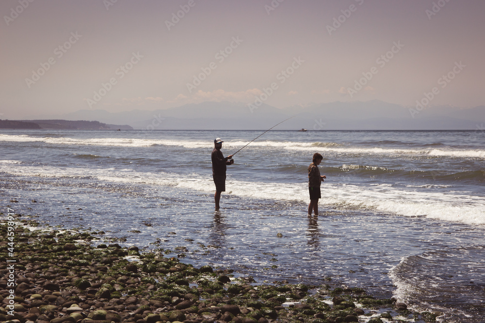 father and son fishing on the beach 