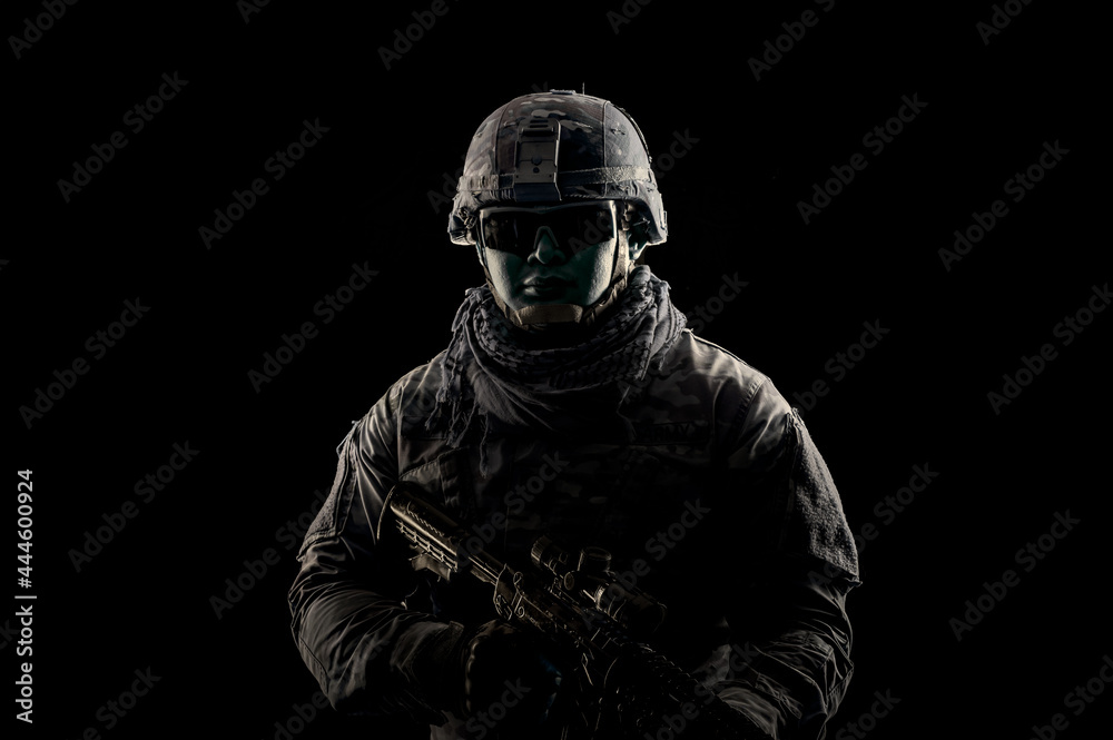 Photo of soldier in black background. Special forces United States soldier or private military contractors holding rifle. Image on black background. soldier, army, war, weapon and technology concept.