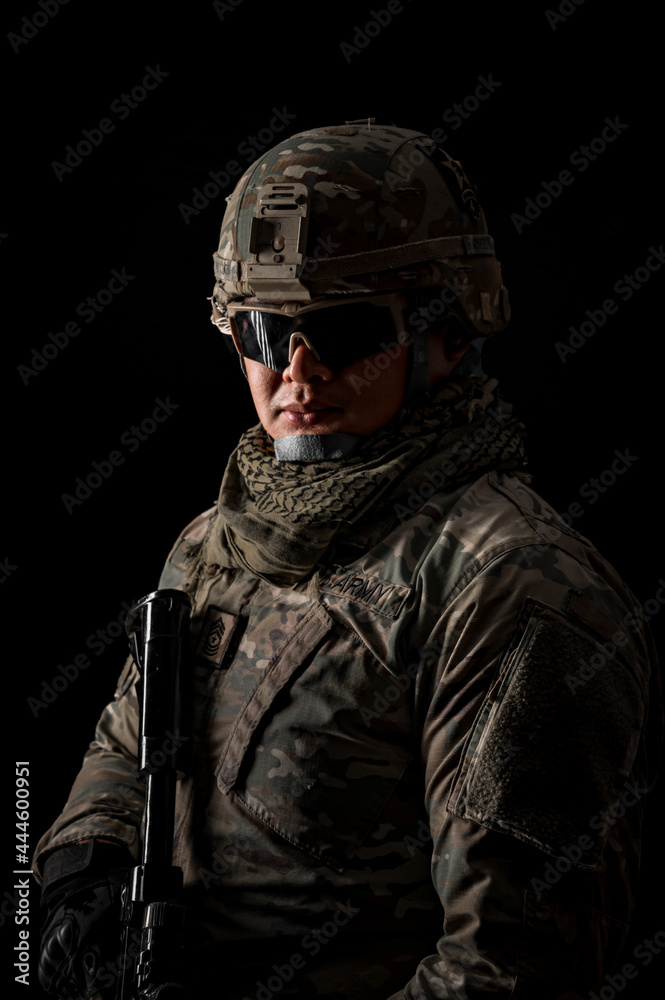 Photo of soldier in black background. Special forces United States soldier or private military contractors holding rifle. Image on black background. soldier, army, war, weapon and technology concept.