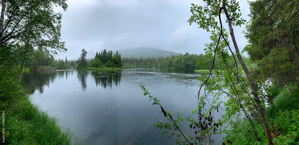 Dawn on the lake. Smooth water surfacePanoramic view of the calm lake, the surface of the water as a mirror. without ripples. no wind. All banks are overgrown with forest. idyll. Morning for fishing.