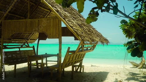 Tropical beach with bungalows under palm trees of Daco, Philippines. Summer and travel vacation concept photo