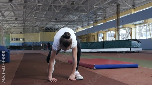 girl - a child shows exercises before the competition for body flexibility in the sports hall. The child is a gymnast. Children photo