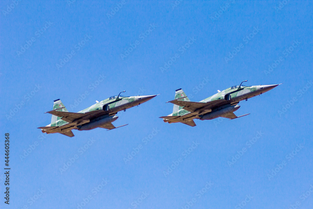 Brasília-DF, Brazil, September,07,2016 - Two F5 fighter planes flying in formation with blue sky background in selective focus Brasília-DF, Brazil, September,07,2016 - Two F5 fighter planes flying in formation with blue sky background in selective focus