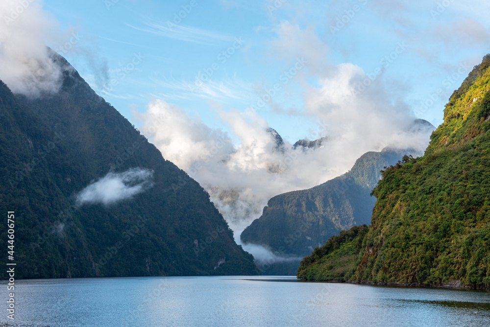 Sun rising over Doubtful Sound, Clouds hanging low on the mountains, Fiordland National Park, New Zealand