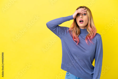 Young woman over isolated yellow background doing surprise gesture while looking to the side © luismolinero