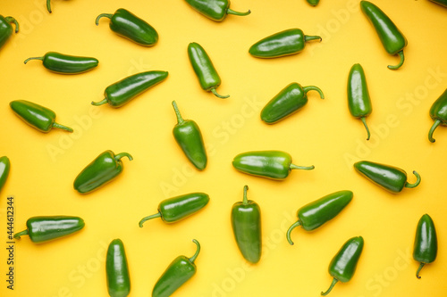 Jalapeno peppers on a yellow background, top view. Green chili pepper.