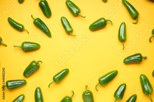 Jalapeno peppers on a yellow background, place for text, top view. Green chili pepper.