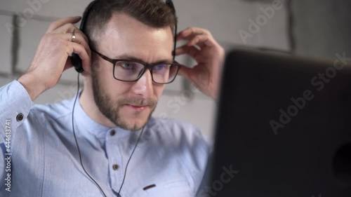 Call center worker puts on headphones and starts working with clients