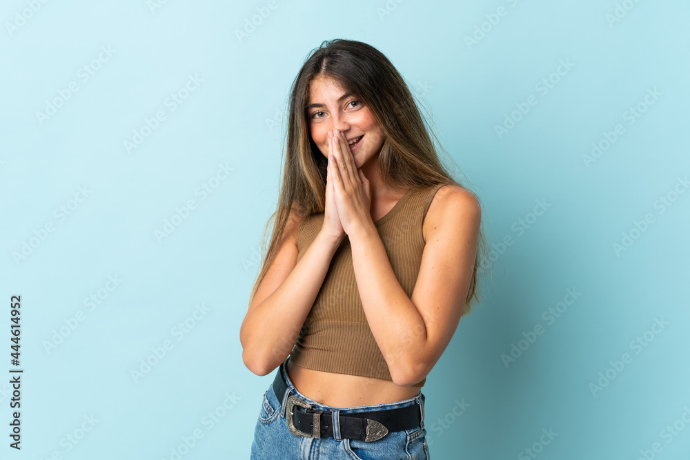 Young caucasian woman isolated on blue background keeps palm together. Person asks for something Young caucasian woman isolated on blue background keeps palm together. Person asks for something