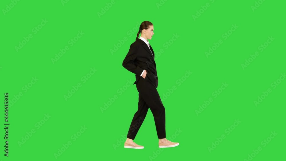Young woman in office suit walking in fashionable style on a Green Screen, Chroma Key. Young woman in office suit walking in fashionable style on a Green Screen, Chroma Key.