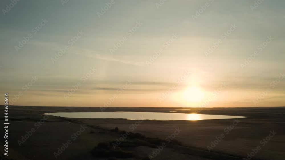 Sunset above body of water lake in rural land of Saskatchewan, aerial Sunset above body of water lake in rural land of Saskatchewan, aerial