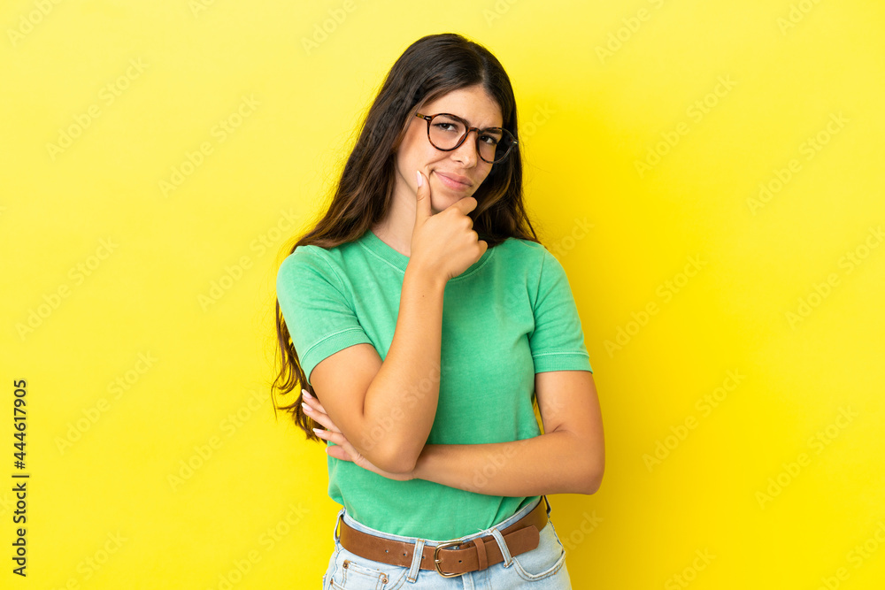 Young caucasian woman isolated on yellow background having doubts Young caucasian woman isolated on yellow background having doubts