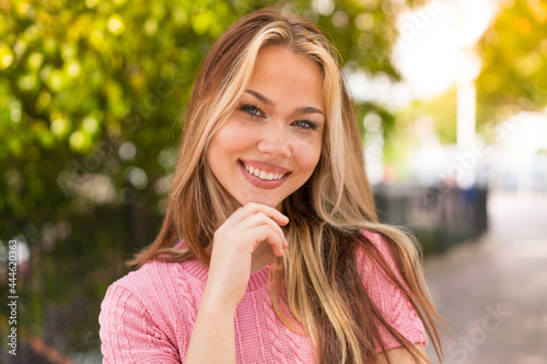 Young pretty blonde girl at outdoors With happy expression