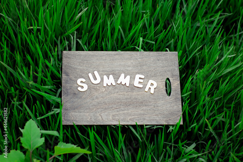 wooden background, with the word summer made of small wooden letters © khanfus