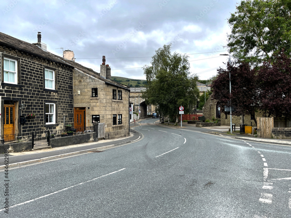 Junction of, Scout Road, with houses, trees, and a cloudy sky in, Mytholmroyd, Hebden Bridge, UK