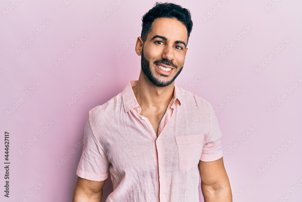 Young hispanic man wearing casual clothes looking positive and happy standing and smiling with a confident smile showing teeth Young hispanic man wearing casual clothes looking positive and happy standing and smiling with a confident smile showing teeth
