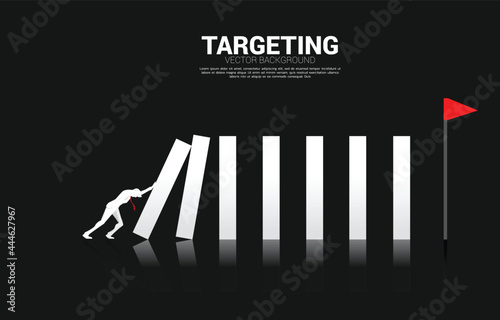 Silhouette of businessman pushing the block to create domino effect to hit the goal. business concept of try to make the domino effect