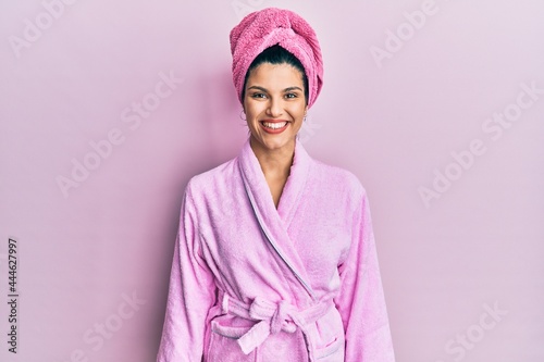 Young hispanic woman wearing shower towel cap and bathrobe with a happy and cool smile on face. lucky person. photo