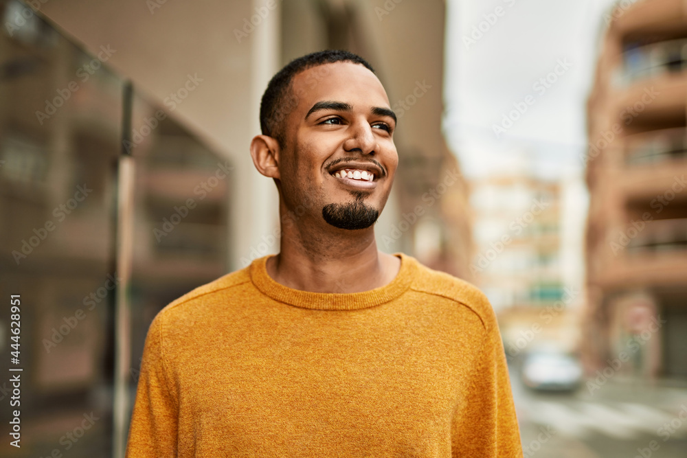 Young african american man smiling happy standing at the city. Young african american man smiling happy standing at the city.
