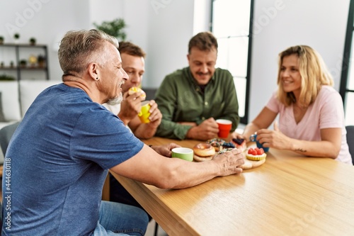 Group of middle age friends having breakfast sitting on the table at home.
