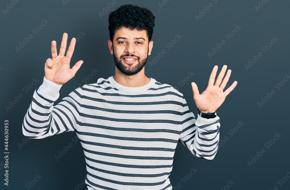 Young arab man with beard wearing casual striped sweater showing and pointing up with fingers number nine while smiling confident and happy. Young arab man with beard wearing casual striped sweater showing and pointing up with fingers number nine while smiling confident and happy.