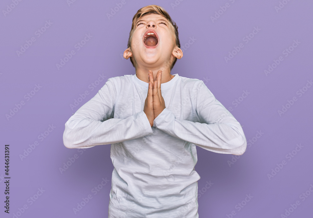 Little caucasian boy kid wearing casual clothes begging and praying with hands together with hope expression on face very emotional and worried. begging. Little caucasian boy kid wearing casual clothes begging and praying with hands together with hope expression on face very emotional and worried. begging.