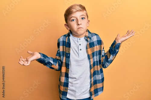 Little caucasian boy kid wearing casual clothes clueless and confused expression with arms and hands raised. doubt concept.