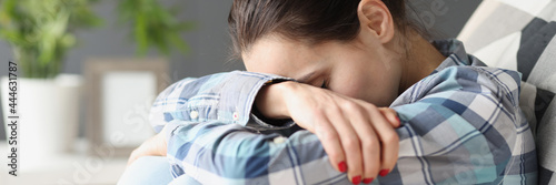 Sad woman sitting with her head bowed on sofa photo