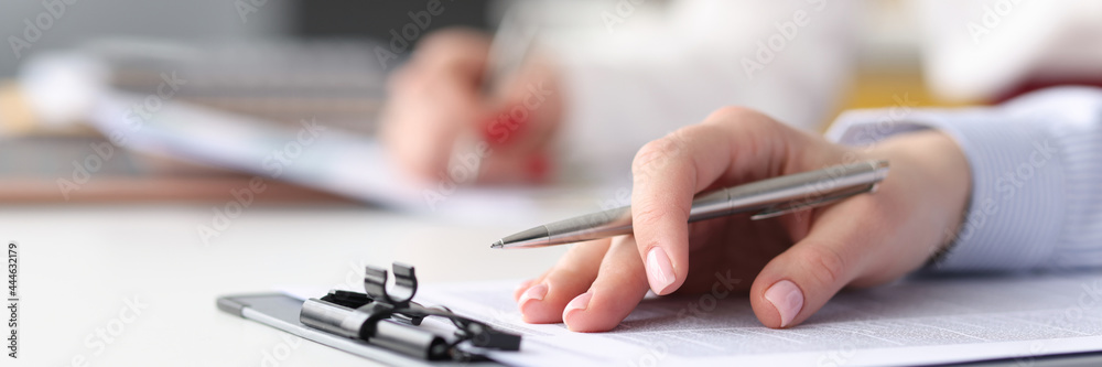 Female hand with ballpoint pen lying on documents closeup - obrazy, fototapety, plakaty 