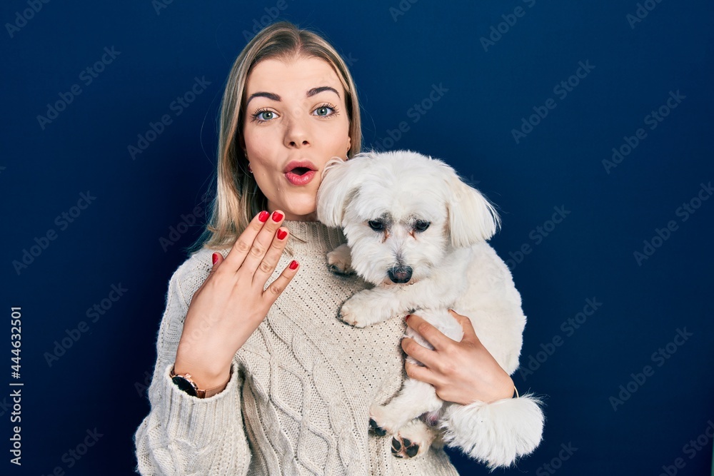 Beautiful caucasian woman hugging cute dog covering mouth with hand, shocked and afraid for mistake. surprised expression Beautiful caucasian woman hugging cute dog covering mouth with hand, shocked and afraid for mistake. surprised expression