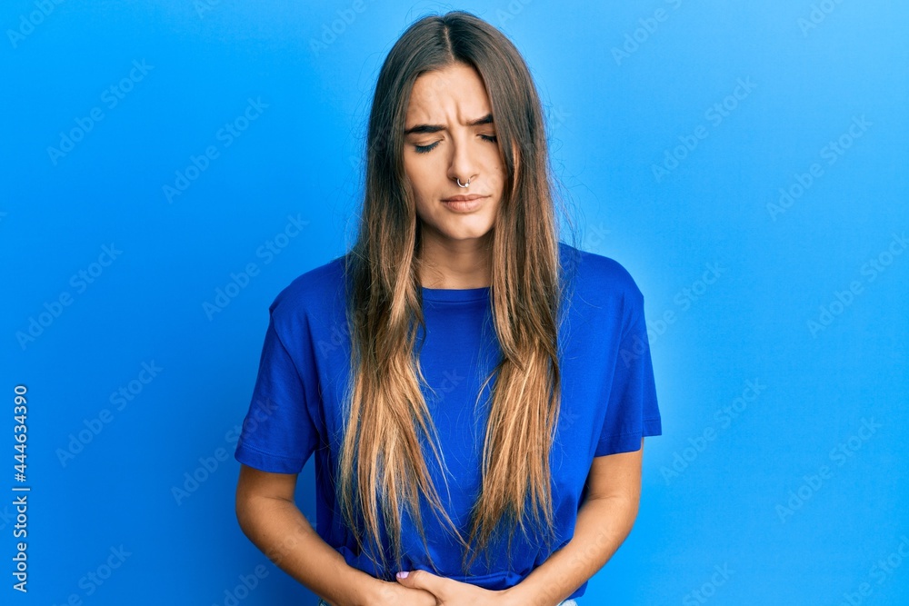 Young hispanic woman wearing casual clothes with hand on stomach because indigestion, painful illness feeling unwell. ache concept. Young hispanic woman wearing casual clothes with hand on stomach because indigestion, painful illness feeling unwell. ache concept.