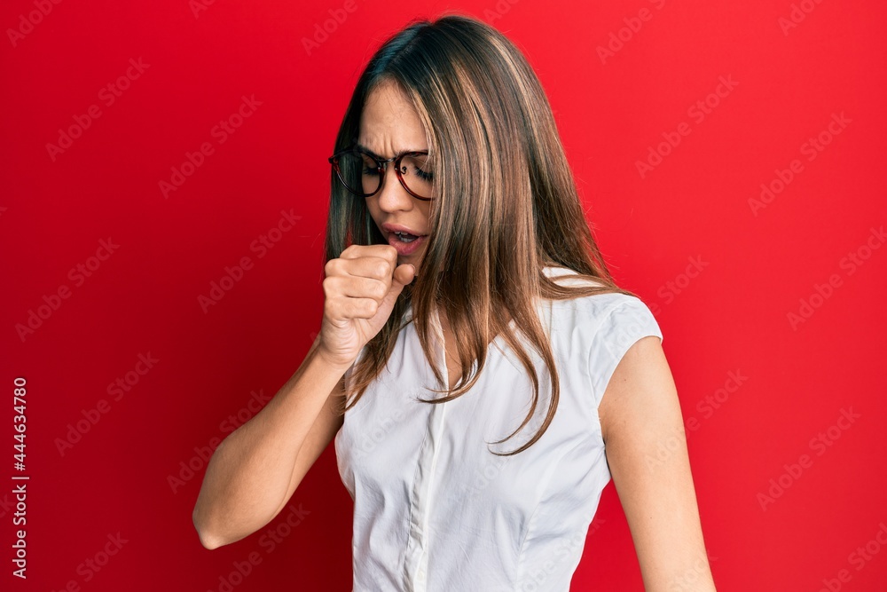 Young brunette woman wearing casual clothes and glasses feeling unwell and coughing as symptom for cold or bronchitis. health care concept. Young brunette woman wearing casual clothes and glasses feeling unwell and coughing as symptom for cold or bronchitis. health care concept.