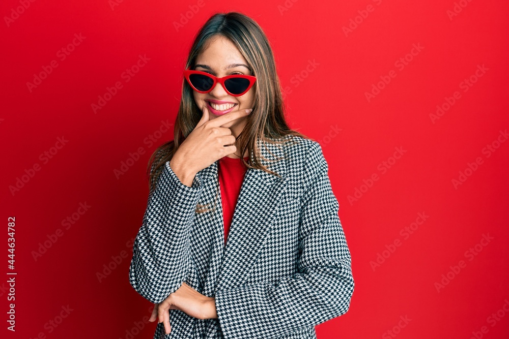 Fototapeta premium Young brunette woman wearing fashion and modern look looking confident at the camera smiling with crossed arms and hand raised on chin. thinking positive.