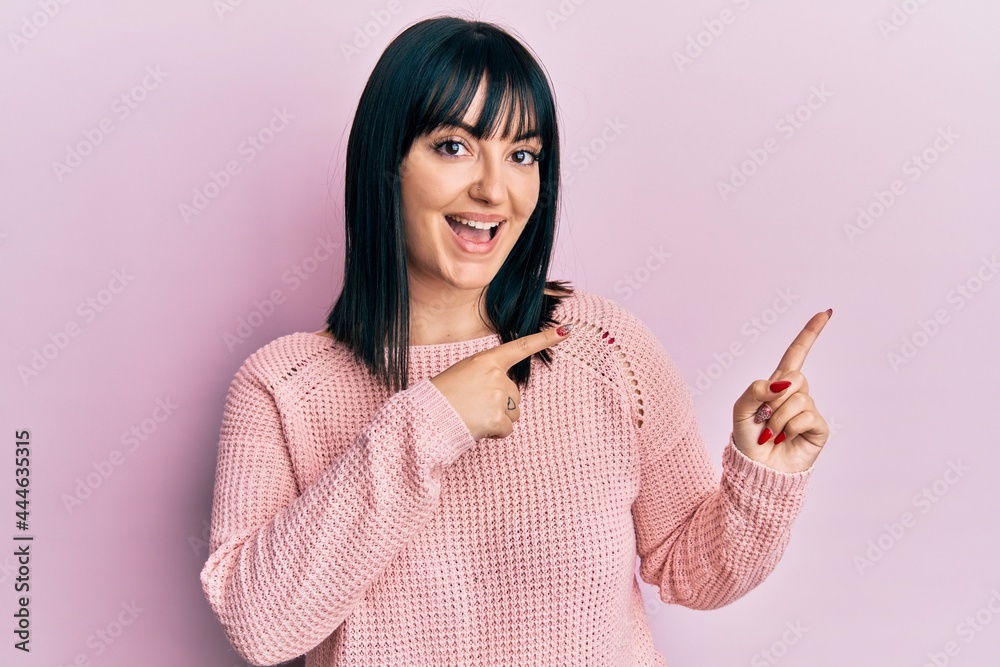Young hispanic woman wearing casual clothes smiling and looking at the camera pointing with two hands and fingers to the side. Young hispanic woman wearing casual clothes smiling and looking at the camera pointing with two hands and fingers to the side.