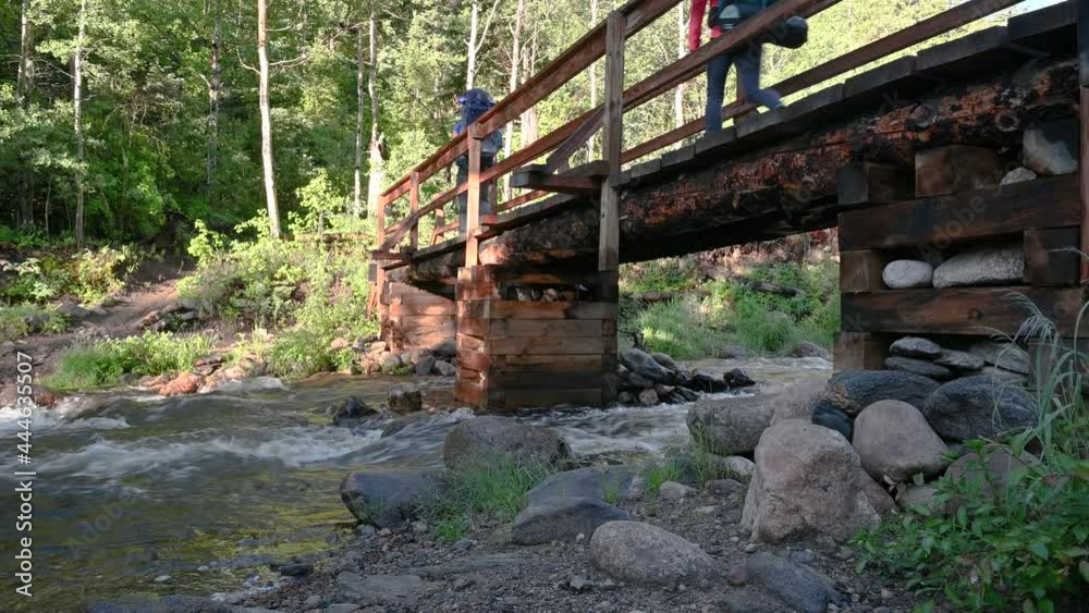 Two Hikers Cross a Stream using a Bridge Two Hikers Cross a Stream using a Bridge