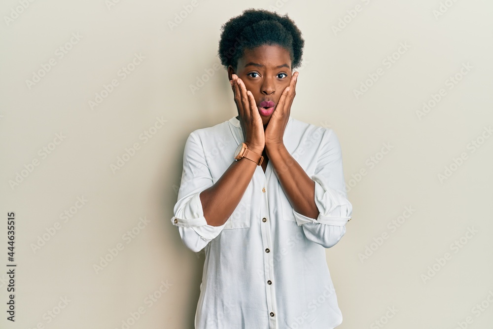 Young african american girl wearing casual clothes afraid and shocked, surprise and amazed expression with hands on face Young african american girl wearing casual clothes afraid and shocked, surprise and amazed expression with hands on face